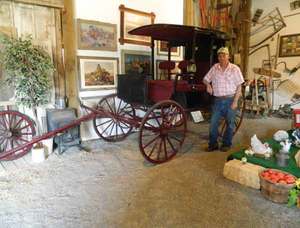 Jack Lawson, co-owner of Lawson’s Emu-Z-Um, poses with a 1910 Rockaway Carriage that was used as an elite taxi. 